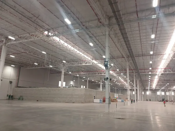 Nave terminada y vacía, con piso pulido y luminarias en línea