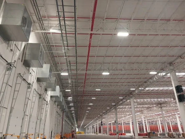 Estructura de techo de la nave con ductos, tubería contra incendio y luminarias colgadas
