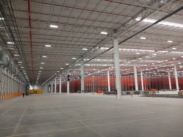 Nave con racking rojo montado, vista hacia el fondo del edificio