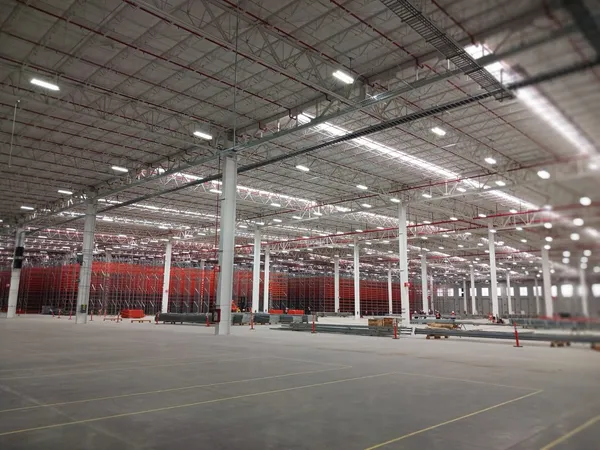 Vista general de la nave con racking industrial y luminarias encendidas