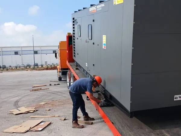 Técnico preparando el grupo electrógeno sobre la plataforma antes de bajarlo