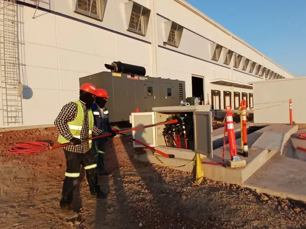 Trabajador ejecutando maniobra junto al equipo instalado al pie del edificio