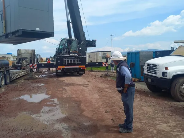 Maniobra de descarga de equipo con grúa en el terreno de la planta
