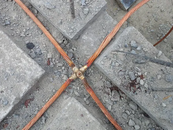 Cruce de ductos naranja embebidos en el piso de concreto