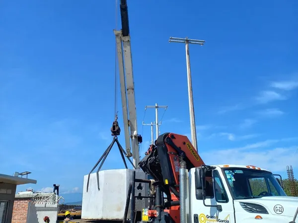 Camión grúa descargando equipo a su llegada al sitio