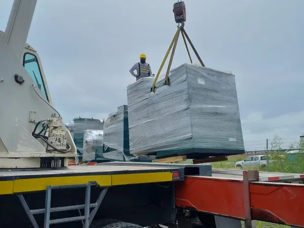 Grúa cargando una pieza de concreto prefabricado sobre la plataforma