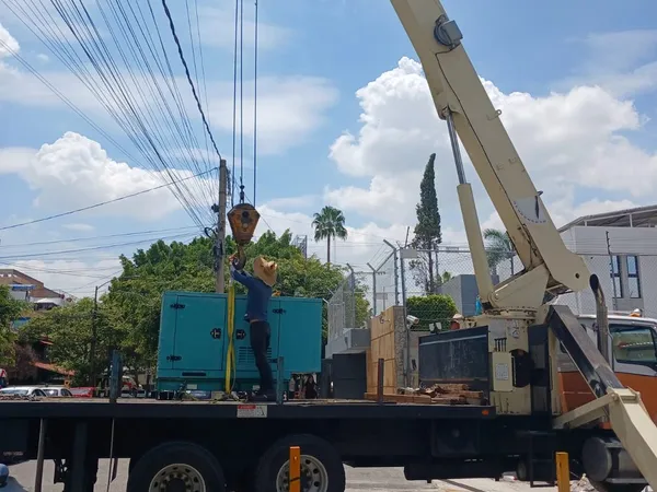Camión grúa maniobrando en la vialidad para entregar el equipo