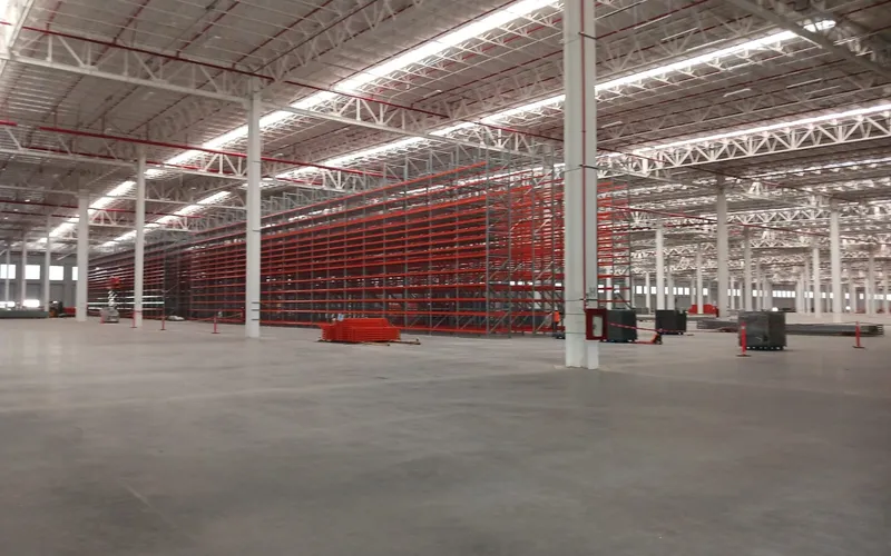 Nave industrial ampliada con racks de almacenamiento y luminarias instaladas