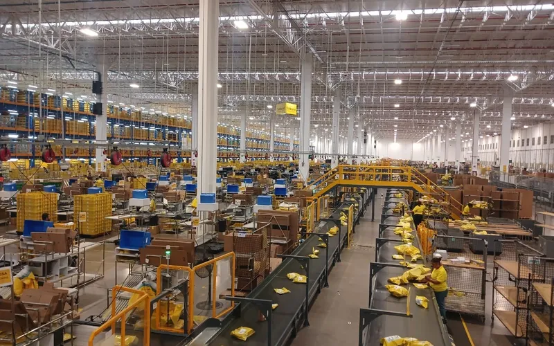 Bandas transportadoras y estaciones de trabajo en operación dentro del centro de distribución de Mercado Libre